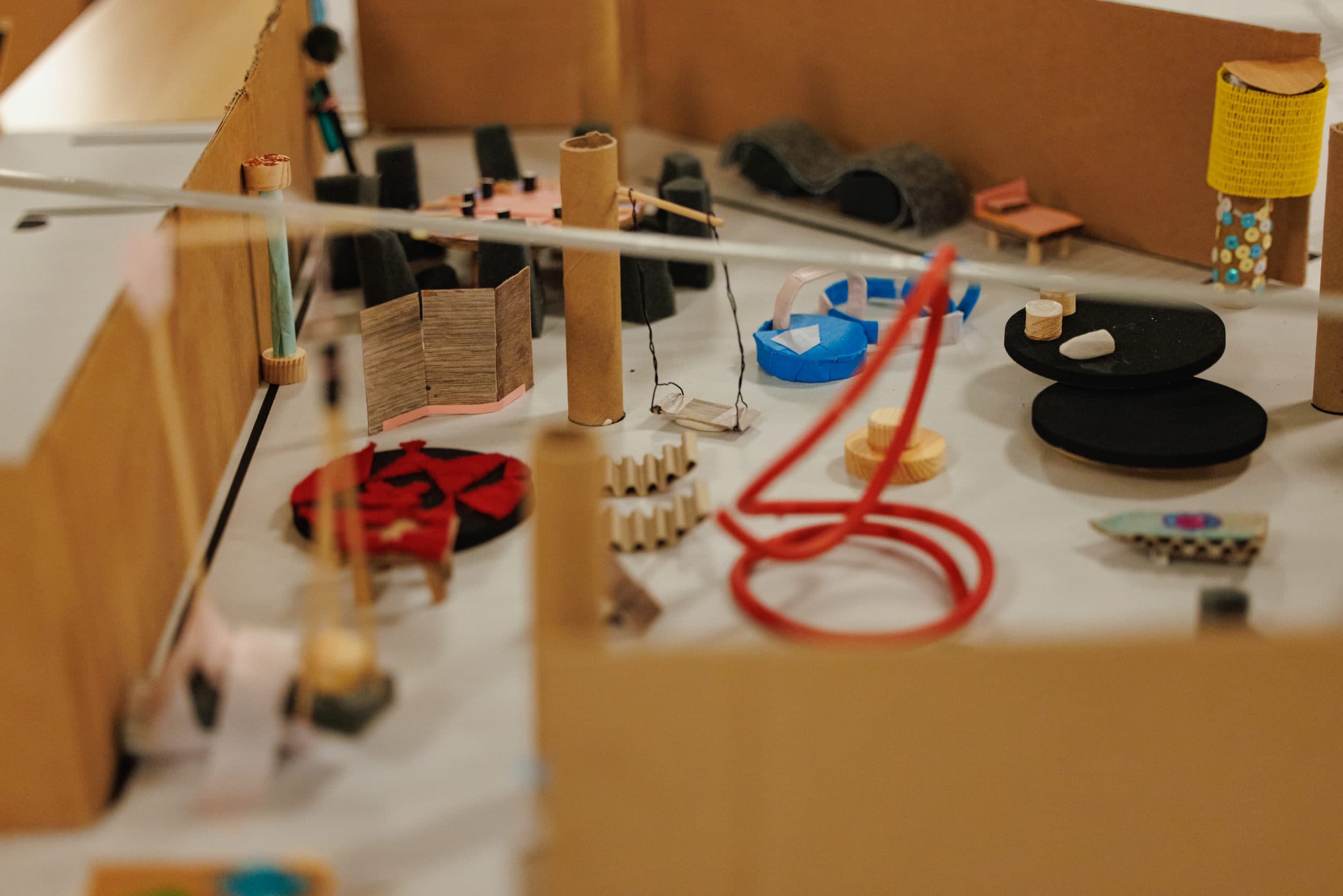 Gros plan d'une maquette d'architecture en carton, ficelle, bois et autres matériaux de récupération.