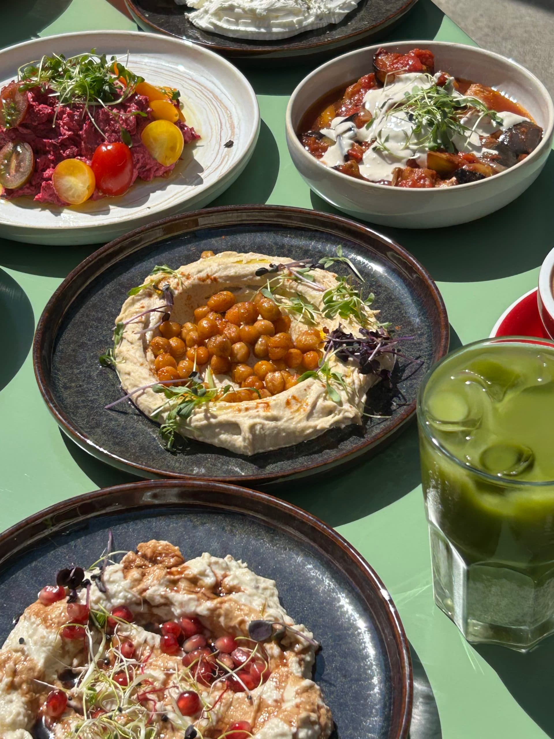 A table with several dishes to share, drinks and plates of Mediterranean cuisine.